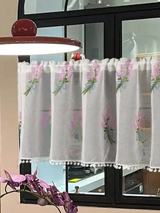 Close-up of lavender embroidered sheer cafe curtain with decorative pom-pom trim