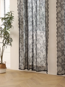 Close-up of black wave lace sheer curtain with floral patterns and scalloped edges
