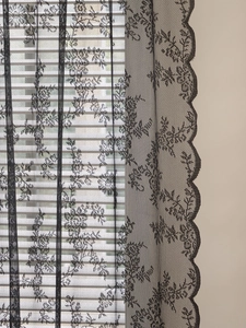 Detail showing vintage black floral lace curtain with scalloped embroidery edges