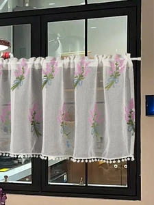 Detail of white cafe curtain with lavender embroidery and white pom-pom trim for kitchen