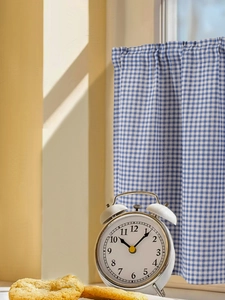 Blue gingham cafe curtain with rod pocket design and soft morning sunlight shadows