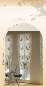 Detail of white sheer curtain with colorful butterfly embroidery and scalloped edges