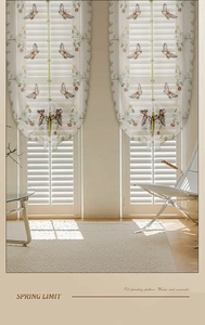 Detail of white embroidered roman valance with butterfly and floral patterns on sheer fabric