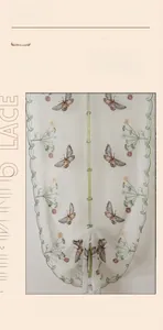 Close-up of white lace curtain featuring colorful butterfly embroidery and floral patterns