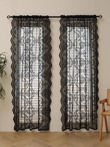 Detail of vintage black lace curtains featuring rose embroidery and scalloped wave edges