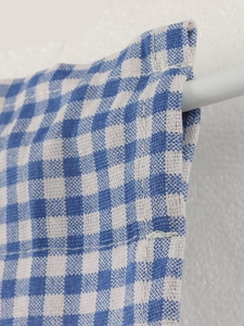 Detail of blue and white gingham door curtain featuring rod pocket and fine stitching
