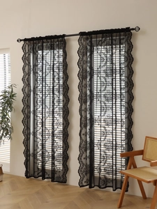 Detail of black lace curtain with floral embroidery and elegant scalloped edges