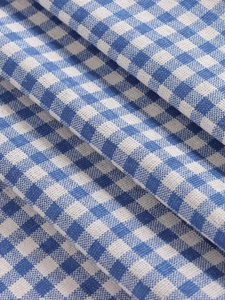 Detailed macro view of the blue and white gingham fabric showing rich cotton-linen texture