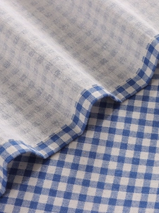 Macro detail of lavender blue gingham fabric showing premium stitching and soft linen texture