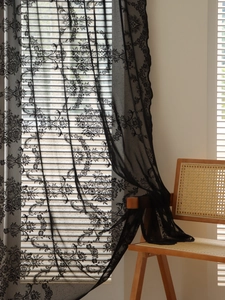 Detail of black floral lace curtain with scalloped edges and vintage French pattern