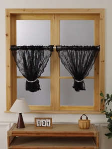 Detail of black French lace curtain with elegant wave edges and pearl drawstring decor