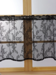 Detail of black lace curtain with rose floral embroidery and ruffled rod pocket top