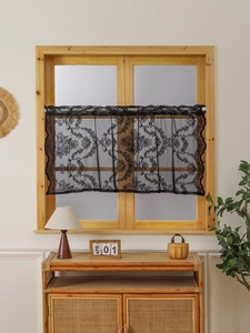 Close-up of black lace cafe curtain featuring intricate floral embroidery on wooden window