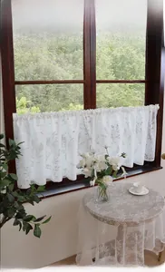 Detailed view of white floral lace cafe curtain with delicate botanical patterns