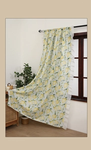 Detail of yellow lemon print curtains with white ruffled edges in a cozy home setting