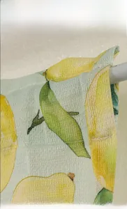 Detail of yellow lemon print on semi-sheer fabric with grid texture for windows