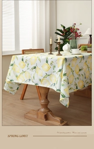Detail of lemon pattern tablecloth on a dining table with warm romantic lighting