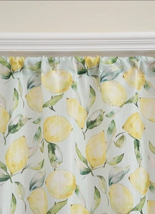 Detail of yellow lemon and green leaf watercolor print on light teal fabric curtain