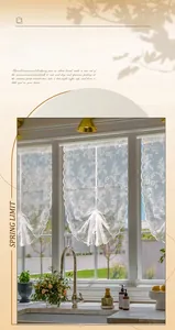 Detail of white floral lace short curtain with elegant wavy edges and drawstring tie-back