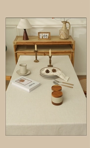 Close-up of minimalist beige linen tablecloth with lace edges in a vintage home setting