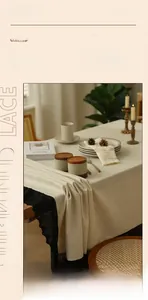 Close-up of beige linen tablecloth with elegant black lace edges and fabric texture