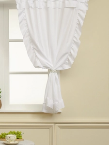 Close-up of white sheer curtain with layered ruffles and elegant pearl tieback detail
