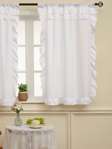 Detail of white semi-sheer curtains with layered ruffle edges and rod pocket design