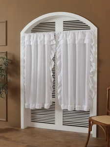 Detail of white ruffle sheer curtain showing delicate fabric texture and layered wavy edges