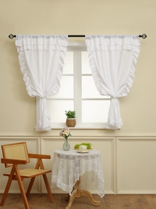 Detail of white layered ruffle sheer curtains with elegant pleated draping and ties
