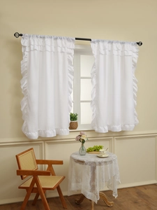 Detail of white ruffled sheer curtains with rod pocket on a black curtain rod