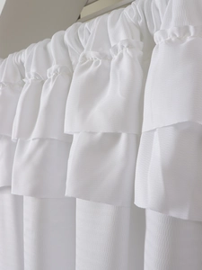 Detail of white multi-layered ruffle sheer curtain with textured waffle weave fabric