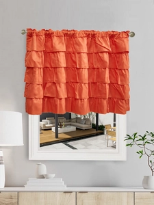 Detail of five-tiered ruffles on a bright orange valance with smooth satin texture