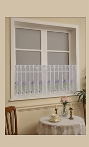 Detail of white lace cafe curtain with purple lavender embroidery and rod pocket