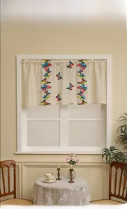Detail of beige lace cafe curtain with butterfly embroidery on white lattice window