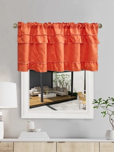 Detail of tiered orange ruffled window valance with white stitching on curtain rod