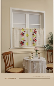 Detail of cafe curtain with ladybug floral prints and embroidered lace edge