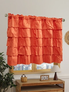 Detail of tiered orange ruffle cafe curtain with smooth satin finish and elegant drapes