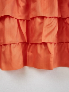 Detail of orange tiered ruffle cafe curtain with mesh texture and layered frill design