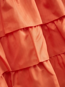 Detail of orange tiered cafe curtain showing ruffled layers and textured waffle weave fabric