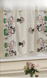 Dettaglio della tenda corta color crema con motivi a funghi verdi e piccoli fiori
