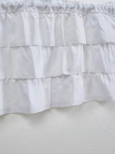 Detailed close-up of white layered ruffles on a vintage American style cafe curtain fabric