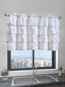 Macro detail of white tiered ruffled valance curtain on a metal rod in a modern kitchen
