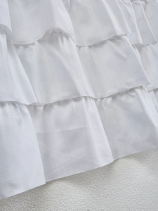 Macro detail of tiered white phantom gauze ruffles showing delicate fabric texture