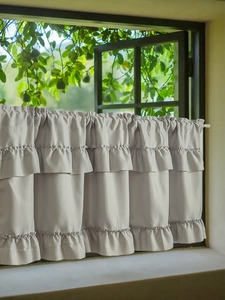 Detail of light gray cafe curtain with triple-layered ruffles and rod pocket design