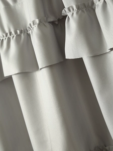 Macro view of light gray coffee curtain featuring ruffled edges and herringbone texture