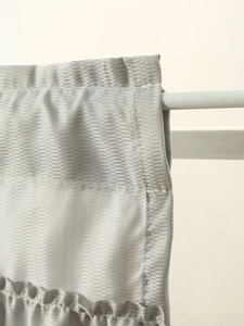 Macro view showing the chevron weave texture and ruffled edge of the silver cafe curtain