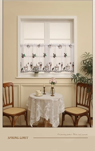 Detail of coffee themed window curtain with embroidery on semi-sheer white fabric