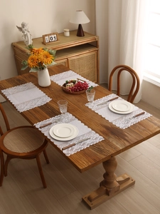 Close-up of white floral lace table mats with elegant scalloped edges set of four