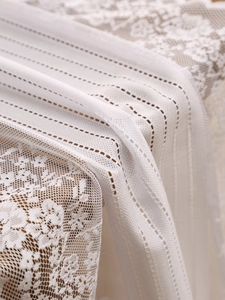 Detail of white hollow floral lace and vertical striped texture on a vintage runner