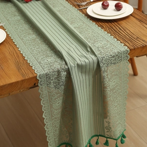 Sage green lace table runner with vintage cutout floral patterns and elegant tassels